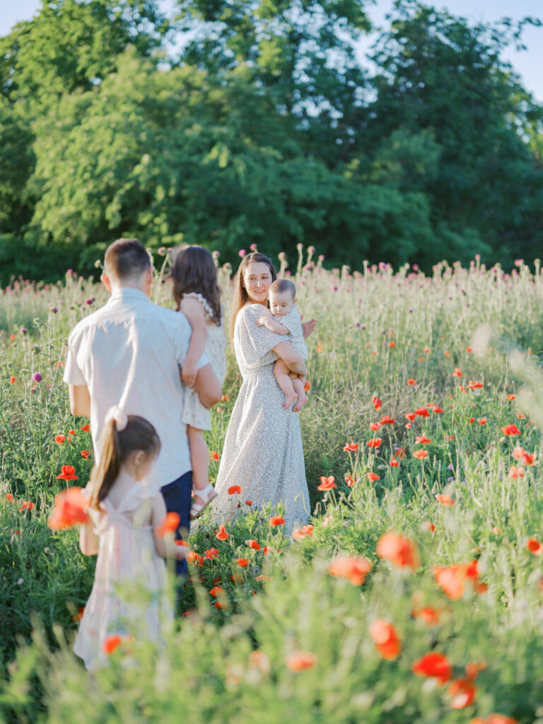 family walks through wildflower field in dfw during family photos