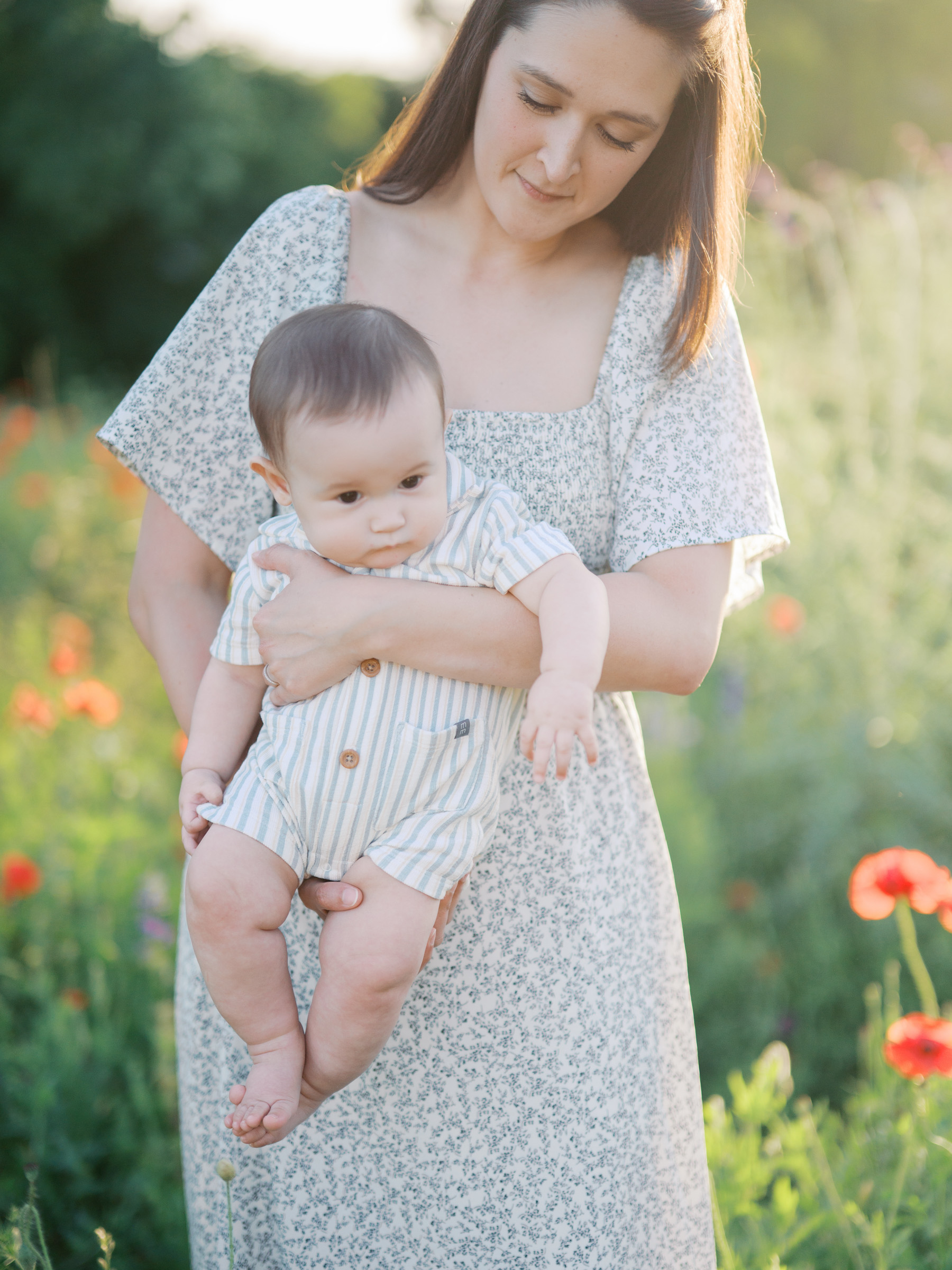 outdoor spring family photos in fort worth and dallas, mom holding baby in wildflower field