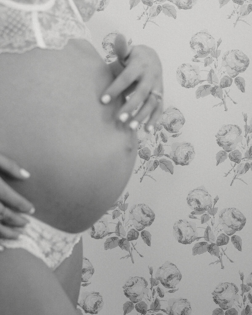 detailed image of expecting mom touching baby bump during maternity photos